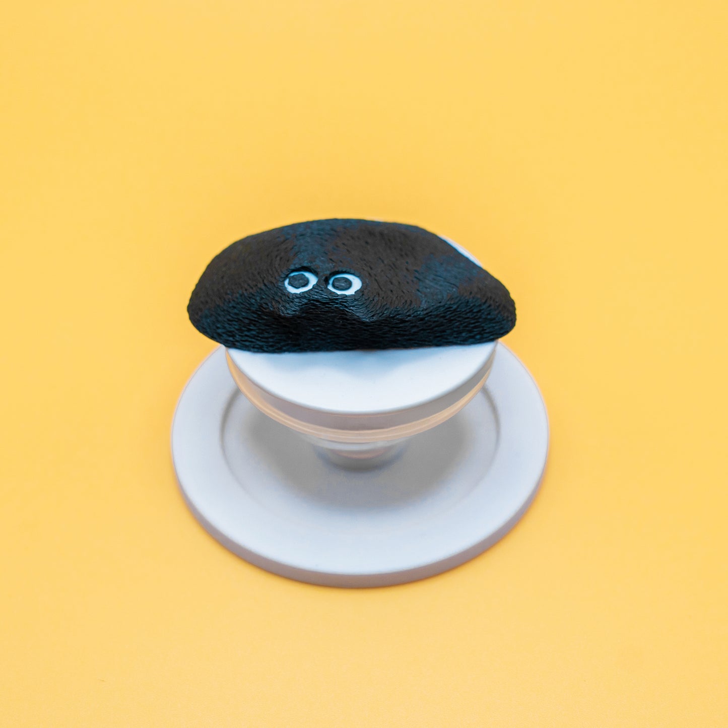 A MagSafe phone grip shaped like a climbing hold, featuring Black Meow the cat – a fun and functional gift for rock climbers and cat lovers.