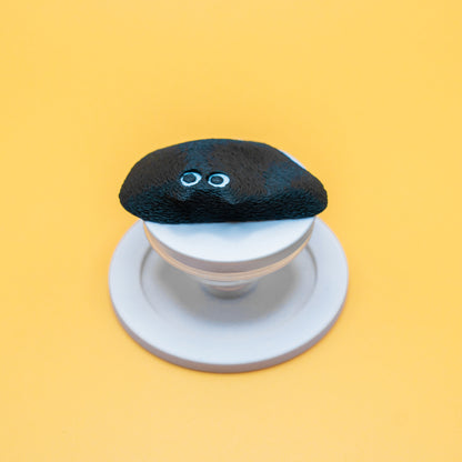 A MagSafe phone grip shaped like a climbing hold, featuring Black Meow the cat – a fun and functional gift for rock climbers and cat lovers.