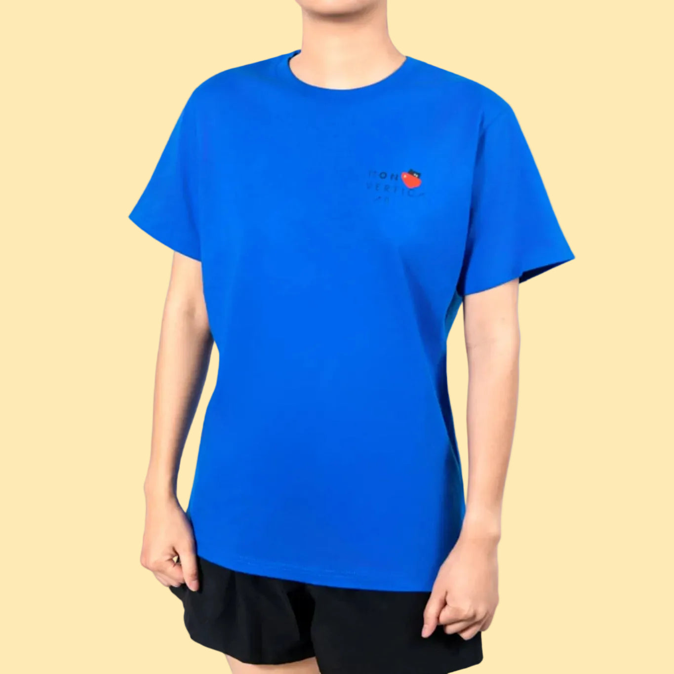 Person wearing a blue t-shirt with a small red and white Non-Vertical Lab logo on a white background