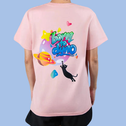 Person wearing a pink t-shirt with colorful graphics and text Born to Dyno on the back, standing against a white background.