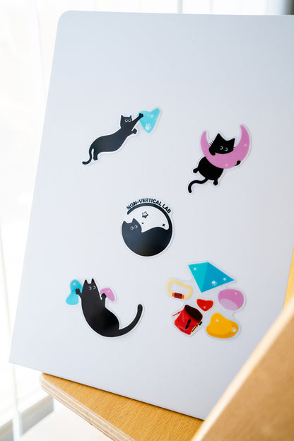 A set of black cats climbing on colorful bouldering holds – printed as a fun sticker sheet for climbers and cat lovers.