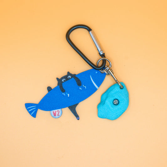 A playful V2 keychain featuring a cat climbing a fish – a fun, climbing-inspired gift for boulderers and rock climbers. Designed by Non Vertical Lab.