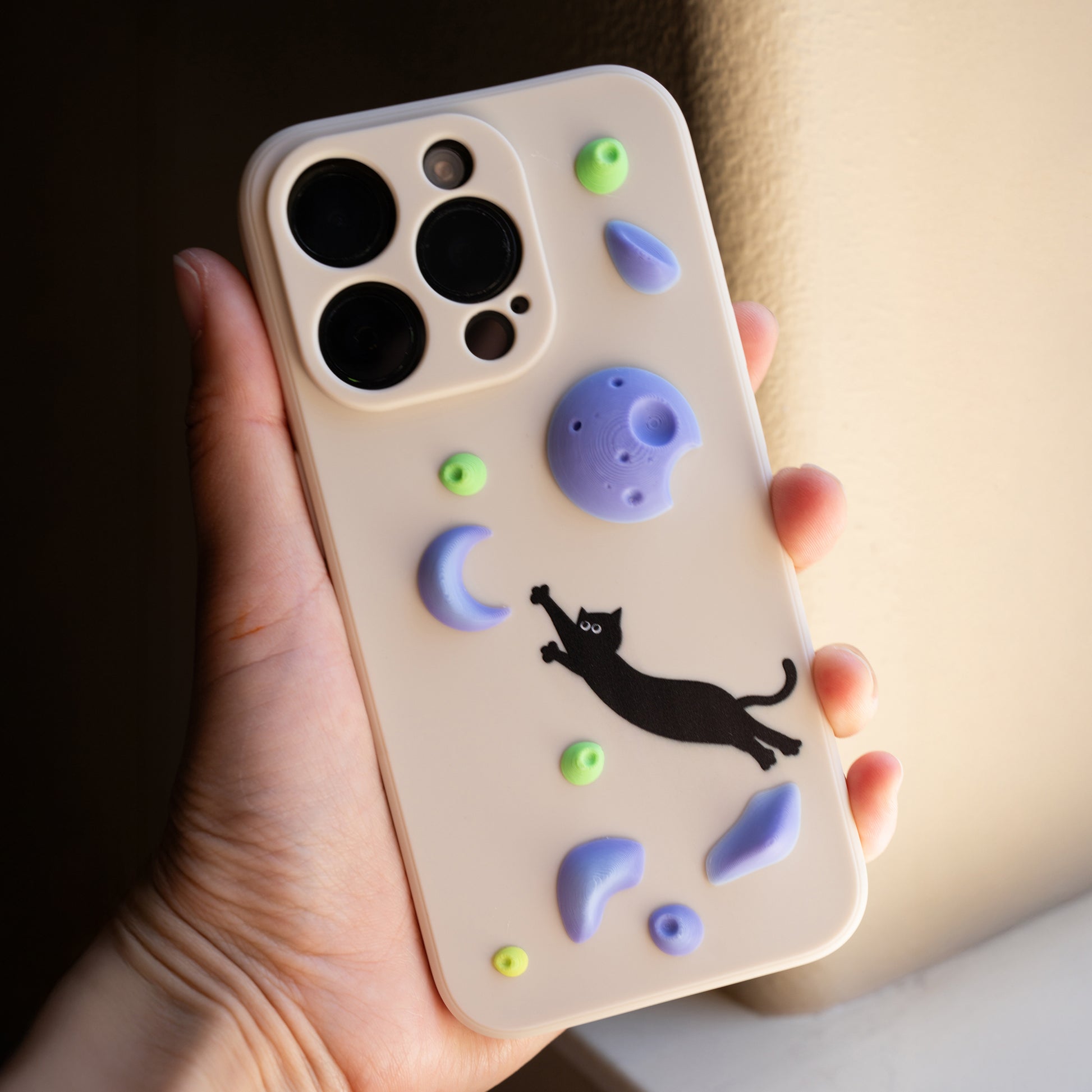 A black cat mid-dyno toward colorful climbing holds – printed on a fun and bold iPhone case. A great gift for climbers and cat lovers.
