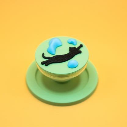 A black cat in mid-air dyno motion, leaping toward climbing holds – printed on a MagSafe phone grip. A bold gift for climbers and cat lovers. Designed by Non Vertical Lab.