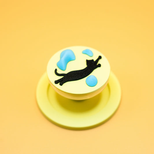 A black cat in mid-air dyno motion, leaping toward climbing holds – printed on a MagSafe phone grip. A bold gift for climbers and cat lovers. Designed by Non Vertical Lab.