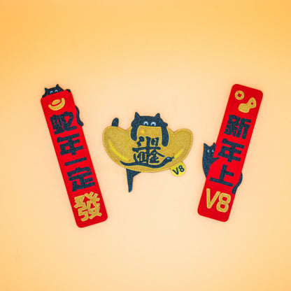 Lucky Cat Fridge Magnet Year of the Snake (V8), featuring a playful black cat climber and festive Lunar New Year elements. Designed to bring good fortune, prosperity, and the spirit of climbing. Perfect as a fridge or workspace decoration and a meaningful gift for climbers. 
 