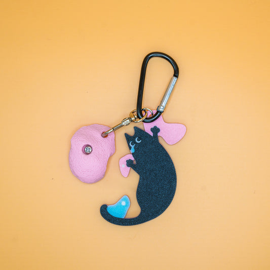 A funny short-armed cat keychain – a relatable and charming gift for climbers who know the struggle of bad reach. Designed by Non Vertical Lab.